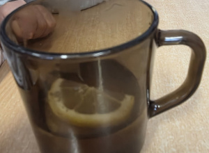 kubki z ciepłym napojem i plasterkami cytryny, dzieci mieszają herbatę przy stole podczas zajęć w przedszkolu